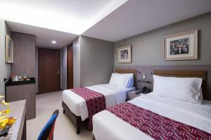 Cette chambre comprend 2 lits et une table. dans l'établissement Solace Hotel, à Manille