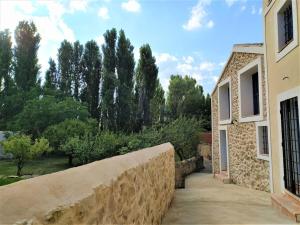 un mur en pierre à côté d'un bâtiment arboré dans l'établissement Casas de Aledo Precioso apartamento con hermosas vistas y jardin, à La Risca