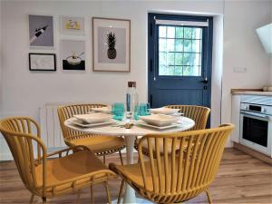 une salle à manger avec une table, des chaises et une porte bleue dans l'établissement Casas de Aledo Precioso apartamento con hermosas vistas y jardin, à La Risca