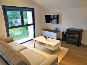 un salon avec un canapé, une table et une télévision dans l'établissement Casas de Aledo Precioso apartamento con hermosas vistas y jardin, à La Risca