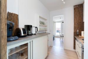 a kitchen with white cabinets and a counter top at Nautic Strandhotel in Sierksdorf