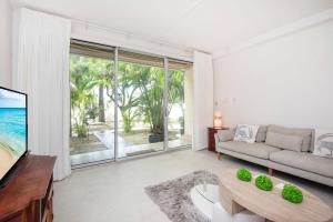 ein Wohnzimmer mit einem Sofa und einem Tisch in der Unterkunft Beach Living at Island Pine Villas BLSE in George Town