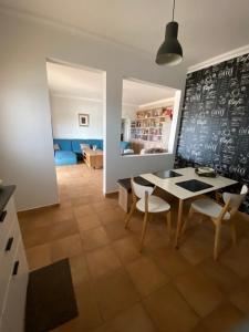 a dining room with a table and chairs and a chalkboard at Casa da azinheira in Loulé