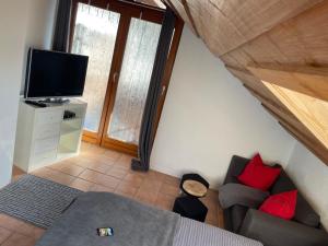 a small living room with a couch and a tv at Birkensteiner Sonnenblick in Fischbachau