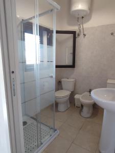 een badkamer met een douche, een toilet en een wastafel bij B&B Mediterraneo in Gela