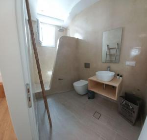 a bathroom with a sink and a toilet and a mirror at Deja vu Ευχάριστο σπίτι στο κέντρο του νησιού ΊΟΥ in Ios Chora