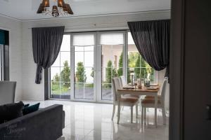 a dining room with a table and chairs and a large window at Дом для всех! in Mārupe