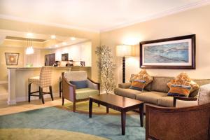 a living room with a couch and chairs and a kitchen at Club Wyndham Panama City Beach in Panama City Beach