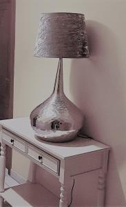 una lámpara sobre una mesa en Hostal Quiper, en Quiroga