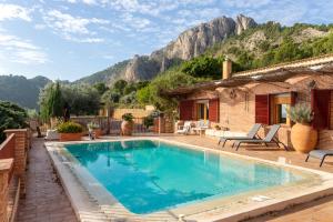 uma casa com piscina com montanhas ao fundo em Casa El Flare em Polop