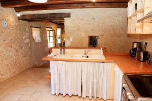 eine Küche mit einer Spüle und einer Arbeitsplatte in der Unterkunft La Petite Maison in Le Bugue