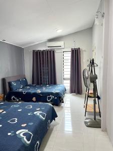 una stanza con due letti e una macchina fotografica di Aina Guest House a Kota Bharu