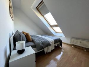 a bedroom with a bed in a attic with a window at R&L Apartment Wettiner Strasse in Leipzig