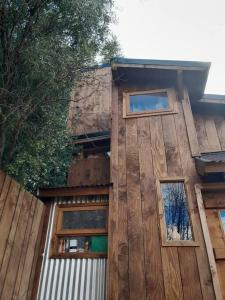 a wooden building with windows on the side of it at Calida Mini Casa in San Carlos de Bariloche