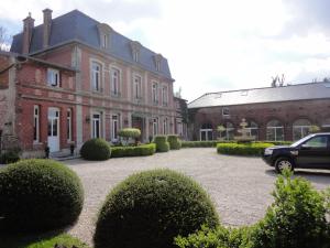 un gran edificio de ladrillo con un coche aparcado delante de él en Manoir le Louis XXI, en Masnières