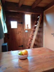 a bowl of fruit on top of a wooden table at Calida Mini Casa in San Carlos de Bariloche