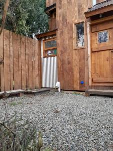 um quintal com uma cerca de madeira e um edifício em Calida Mini Casa em San Carlos de Bariloche