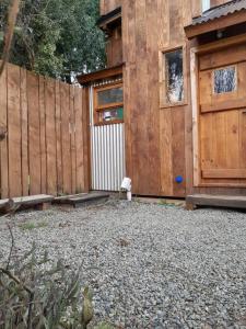 a backyard with a wooden fence and a building at Calida Mini Casa in San Carlos de Bariloche