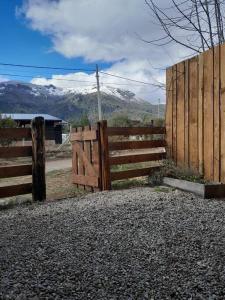 una valla de madera frente a una montaña en Calida Mini Casa en San Carlos de Bariloche