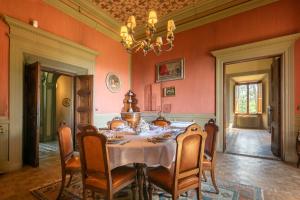 a dining room with a table with chairs and a chandelier at Villa Votanidi by VacaVilla in Borgo San Lorenzo