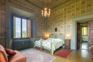 a bedroom with a bed and a chandelier at Villa Votanidi by VacaVilla in Borgo San Lorenzo +33 photos
