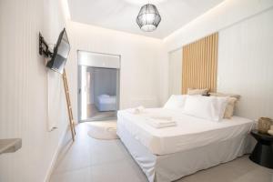 a white bedroom with a bed and a television at Piraeus 1 bedroom 4 persons apartment in Piraeus