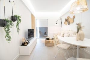 uma sala de estar branca com uma mesa e cadeiras brancas em Piraeus 1 bedroom 4 persons apartment em Pireu