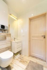 a bathroom with a toilet and a sink and a mirror at Amber Domki in Jarosławiec