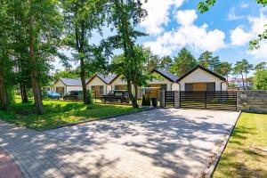 a house with a fence and a driveway at Amber Domki in Jarosławiec