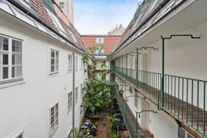 un callejón entre dos edificios con plantas en Florian's apartments in Mariahilf Vienna en Viena