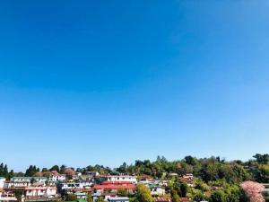 a view of a city with houses on a hill at Pine Hill Comfort Stay in Shillong
