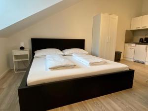 łóżko z białą pościelą i poduszkami w pokoju w obiekcie Central Apartment in Vienna near metro (800m) - T21 w Wiedniu +2 zdjęcia