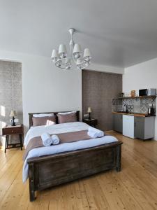 a bedroom with a large bed and a chandelier at Old Gold Anteon in Tbilisi City