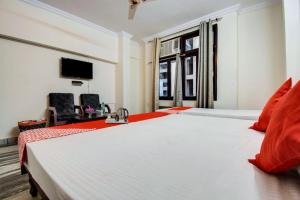 a bedroom with a large white bed with red pillows at Royal Retreat By Hotel Aditya Inn in Jaipur