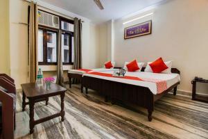 a hotel room with two beds and a table at Royal Retreat By Hotel Aditya Inn in Jaipur