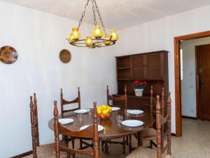 a dining room with a table and a chandelier at Apartment S'Esquirol Nº9 by Interhome in Begur