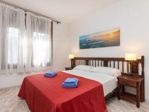 um quarto de hotel com uma cama com um cobertor vermelho em Apartment S'Olivera-5 by Interhome em Begur