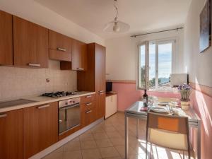 a kitchen with wooden cabinets and a table and a window at Apartment Rosa - PTB150 by Interhome in Pietrabuona