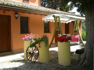 dom z dwoma skrzyniami kwiatów i parasolką w obiekcie B&B Cà Giovanni Country Resort w mieście Urbino