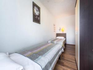 Ce lit se trouve dans un dortoir doté de murs blancs et de parquet. dans l'établissement Prlender Apartment, à Čibača