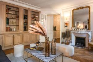 uma sala de estar com uma mesa e uma lareira em Outstanding Apartment - 8 Guests between Tour Eiffel and Invalides em Paris