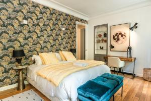 um quarto com uma cama e uma parede coberta de papel de parede em Outstanding Apartment - 8 Guests between Tour Eiffel and Invalides em Paris