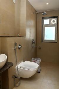 Rājsamandにあるhotel keshav innのバスルーム(トイレ、洗面台付)、窓が備わります。