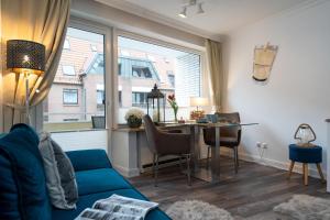 ein Wohnzimmer mit einem blauen Sofa und einem Tisch in der Unterkunft Meeresrauschen in Westerland