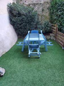 una mesa azul y sillas sentadas en la hierba en Emplacement de 1er choix situé dans une impasse- Prestations de qualité - WiFi, en Cauterets