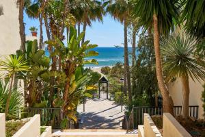 uma vista para a praia a partir de um resort com palmeiras em OleHolidays 326 Romana Playa vistas al mar em Marbella