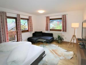 a bedroom with a bed and a couch and windows at Apartment Lisa by Interhome in Neustift im Stubaital