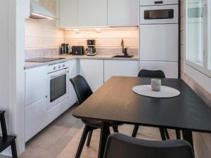 a kitchen with a table and chairs in a kitchen at Holiday Home Kitkanvee 2 by Interhome in Kuusamo