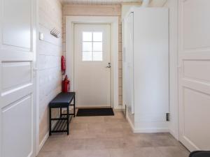 ein Flur mit einer weißen Tür und einem Hocker in der Unterkunft Holiday Home Kitkanvee 2 by Interhome in Kuusamo + 11 Fotos