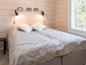a bedroom with a bed with two pillows and a window at Holiday Home Kitkanvee 2 by Interhome in Kuusamo